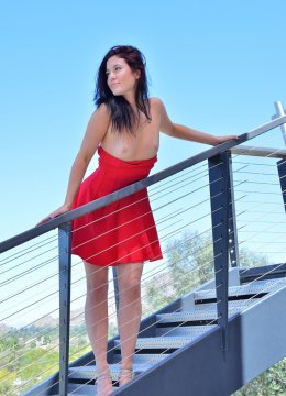 Девушка в коротком красном платье устроила прогулку по лестнице